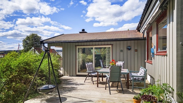 Adkomst til terrasseplatting via skyvedører fra peisestuen. Usjenert og lun uteplass med markise.