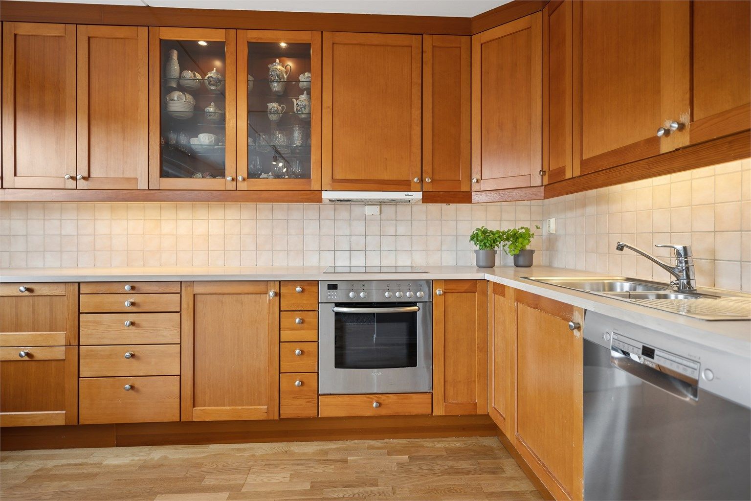 Kjøkkeninnredning fra Sigdal, der flisene står i vakker kontrast til treverket og gir et moderne og harmonisk uttrykk.