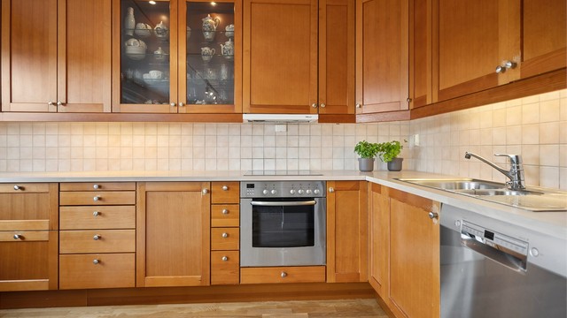 Kjøkkeninnredning fra Sigdal, der flisene står i vakker kontrast til treverket og gir et moderne og harmonisk uttrykk.