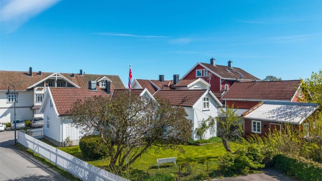 Denne sjarmerende eneboligen fra midten av 1700-tallet er rammet inn av et hvitt stakittgjerde. Innenfor ligger en idyllisk hage med bla. flaggstang og bryggerhus.
Foto: Fotofinish AS v/Kristian Bollæren
