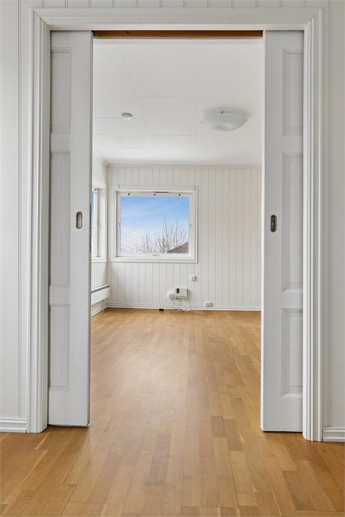 Profilerte innerdører med glassfelt mellom stue og vinterhage bevarer lysflyten.