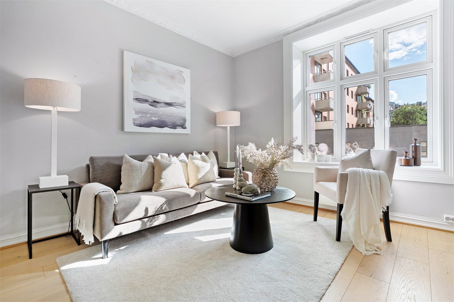 Lys og åpen stue med mye naturlig lysinnslipp fra stor vinusflate.