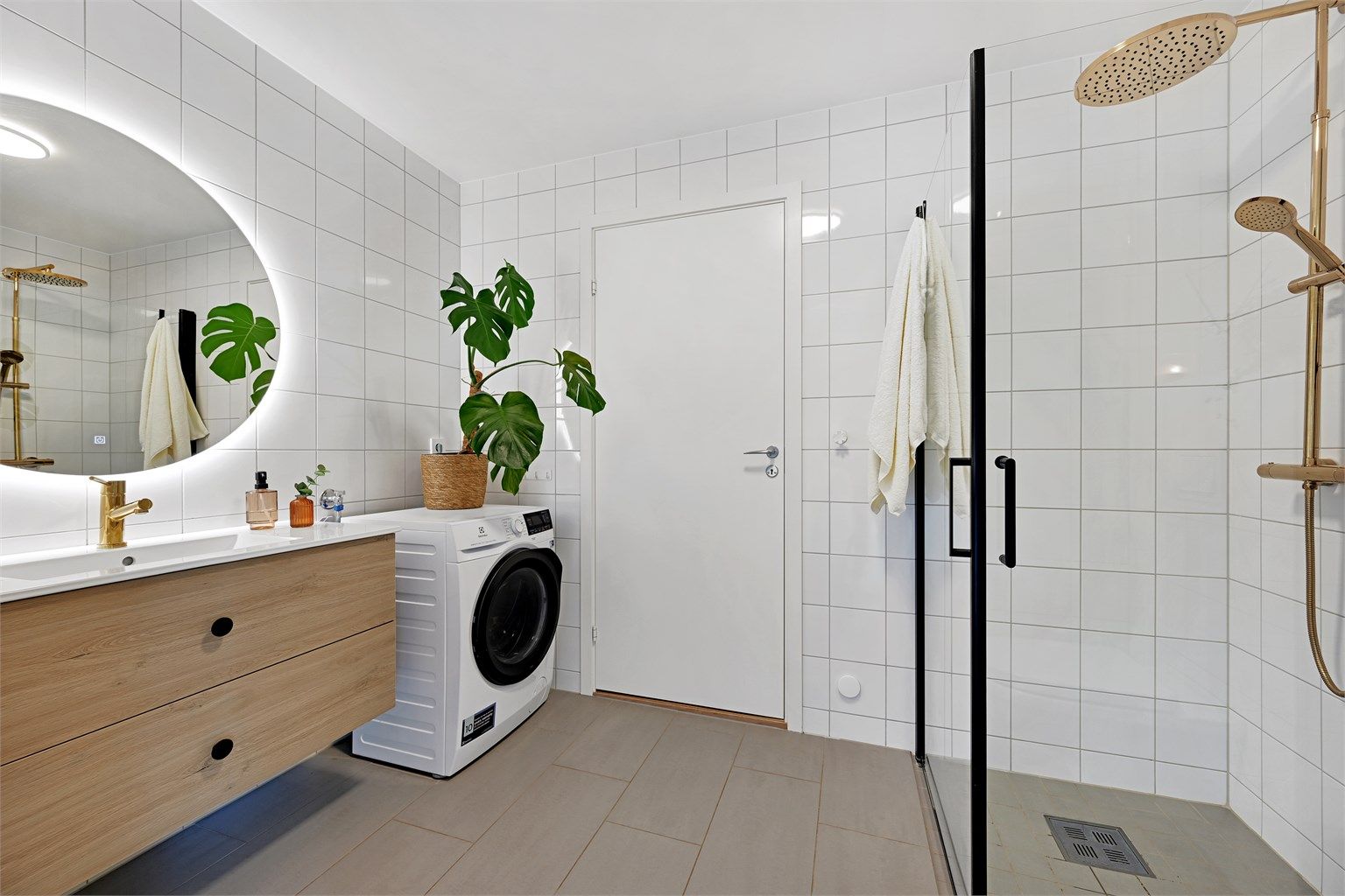 Delikat flislagt bad med elektriske varmekabler, opplegg for vaskemaskin og vegghengt toalett.