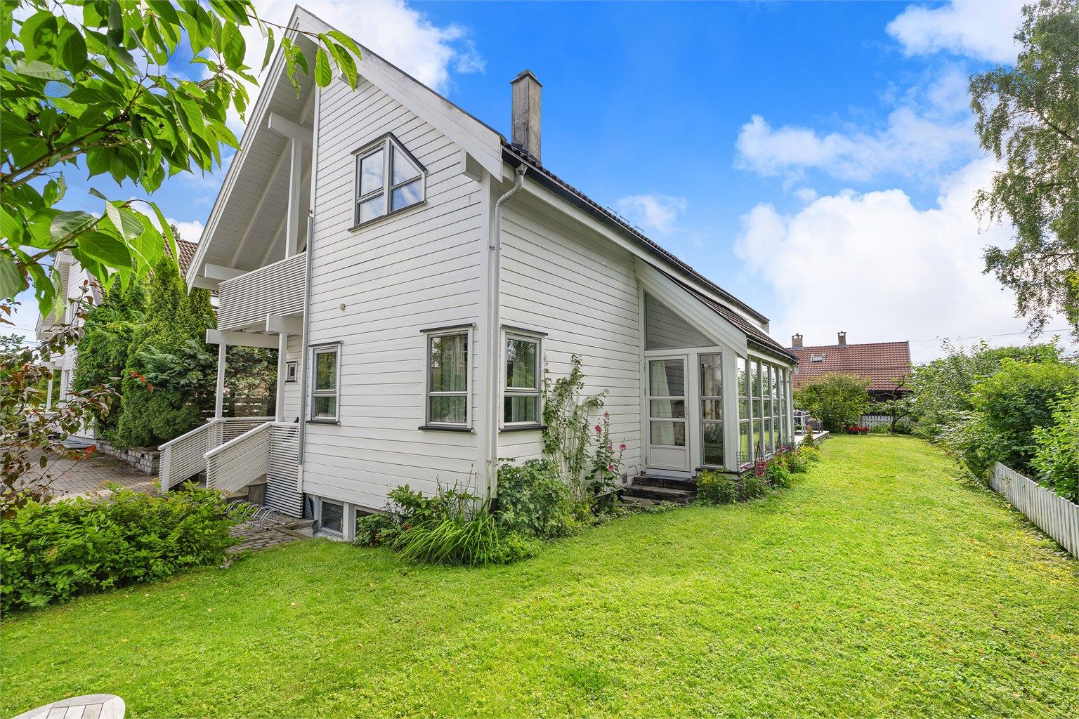 Hagen er pent opparbeidet med plen og diverse beplantning.