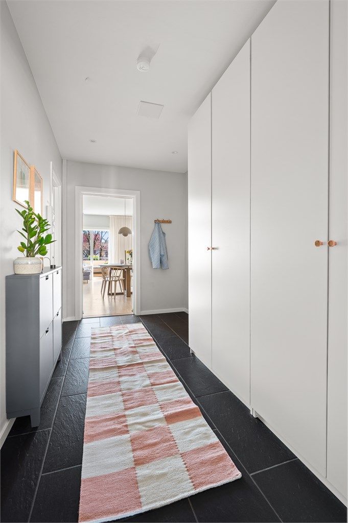 Den romslige gangen har en hel vegg med garderobeskap som gir utmerket lagringskapasitet.