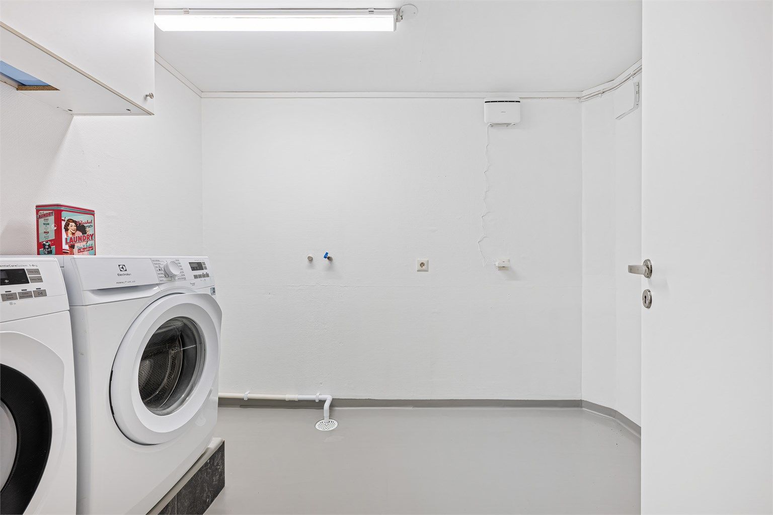 Vaskerommet har nymalte vegger og malt laminat som er lagt oppå betonggulv. Her ligger alt til rette for å lage til et praktisk vaskerom med oppbevaringsplass .Opplegg for vaskemaskin og plass til tørketrommel. 