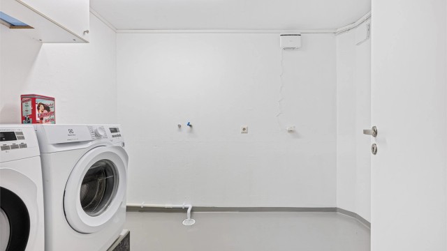 Vaskerommet har nymalte vegger og malt laminat som er lagt oppå betonggulv. Her ligger alt til rette for å lage til et praktisk vaskerom med oppbevaringsplass .Opplegg for vaskemaskin og plass til tørketrommel.