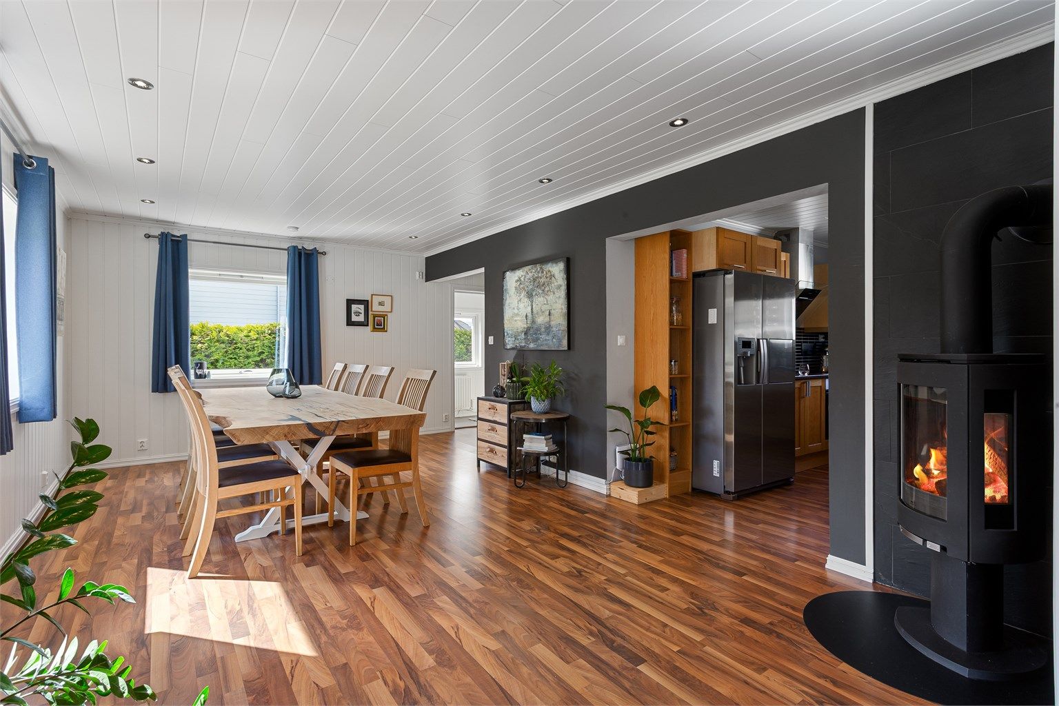 Stue med delvis åpenløsning mot kjøkken - flott vedovn