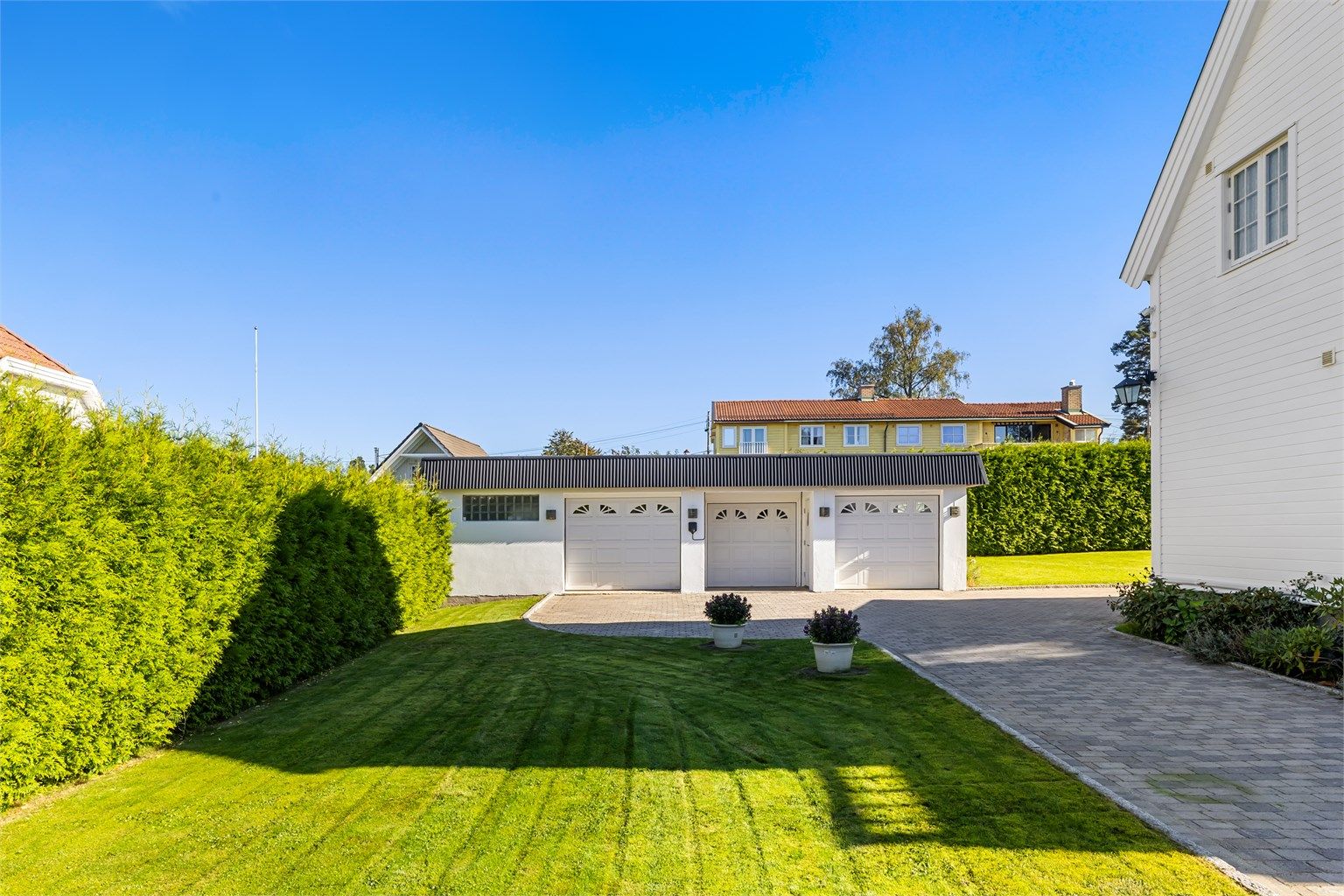 1. etasje i garasjen består av 3 separate garasjer, der en av garasjene er ekstra stor og har tilliggende bod. Alle 3 med elektriske garasjeporter. Elbillader på yttervegg. Stor kjeller under hele garasjen med underjordisk gang mellom hus og garasje