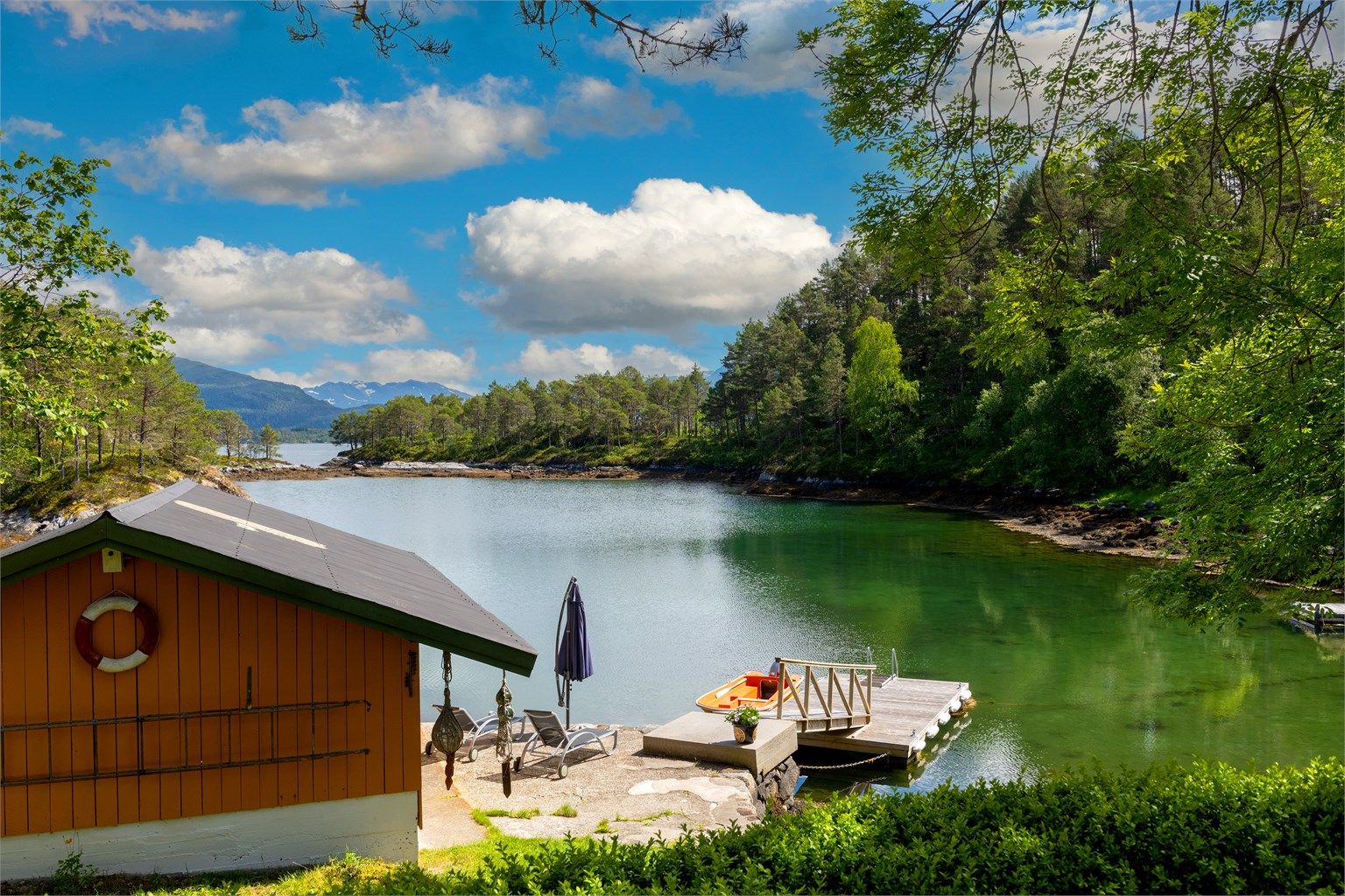 Naustet er beliggende mot øst og grenser til sjøen og en lun vik med bademuligheter