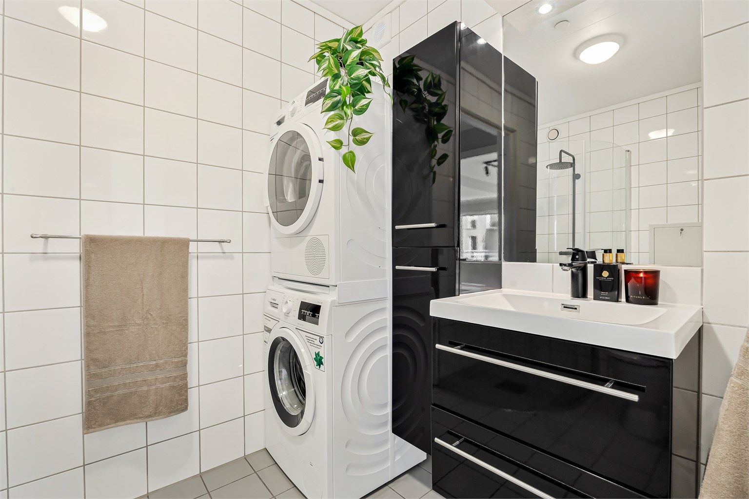 Badet har opplegg for vaskemaskin samt tørketrommel og er utstyrt med høyskap for ekstra oppbevaring.