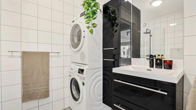 Badet har opplegg for vaskemaskin samt tørketrommel og er utstyrt med høyskap for ekstra oppbevaring.