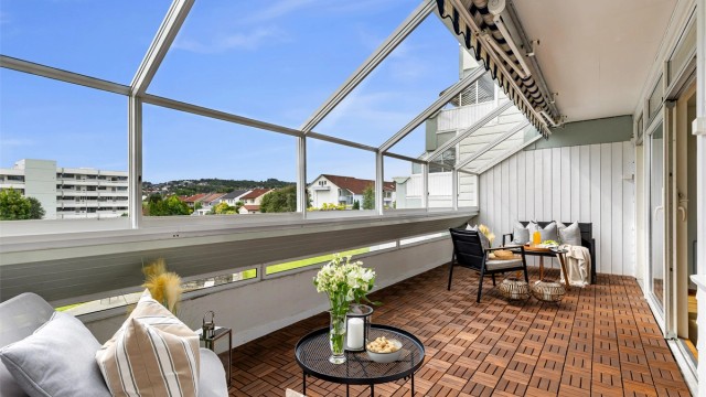 Den store innglassede balkongen på 17 m² fungerer som en forlengelse av stuen store deler av året.