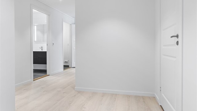 Gjennomgående lys parkett i alle oppholdsrom skaper en helhetlig og moderne følelse.