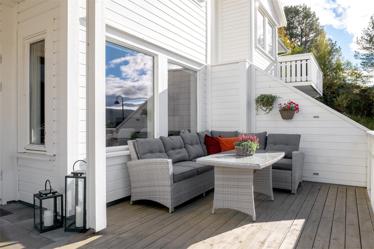 Skjermet hjørne på terrassen med plass til stor sofagruppe.