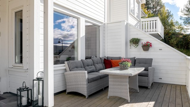 Skjermet hjørne på terrassen med plass til stor sofagruppe.