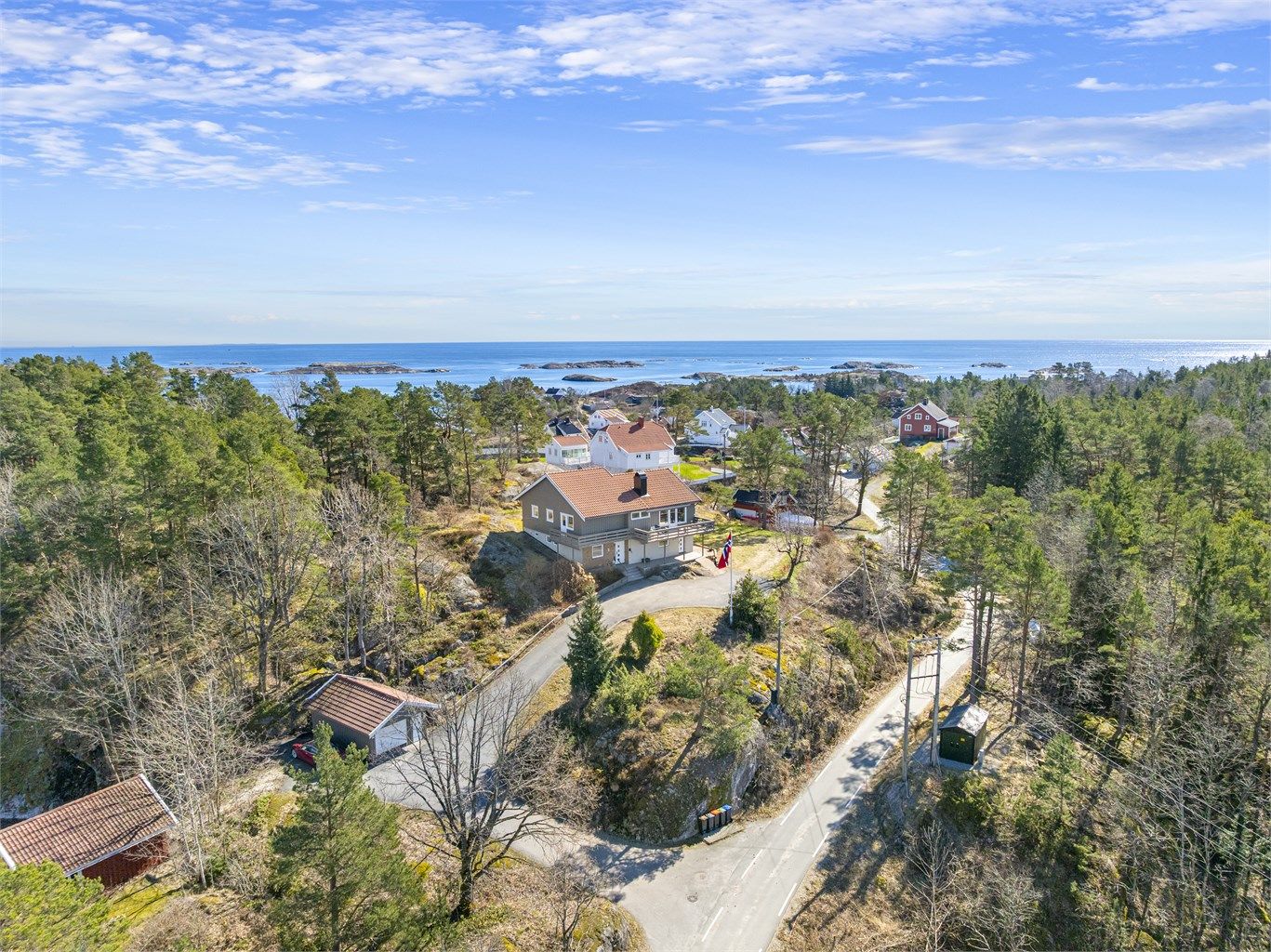 Eiendommen ligger høyt i terrenget med utsikt mot havet.