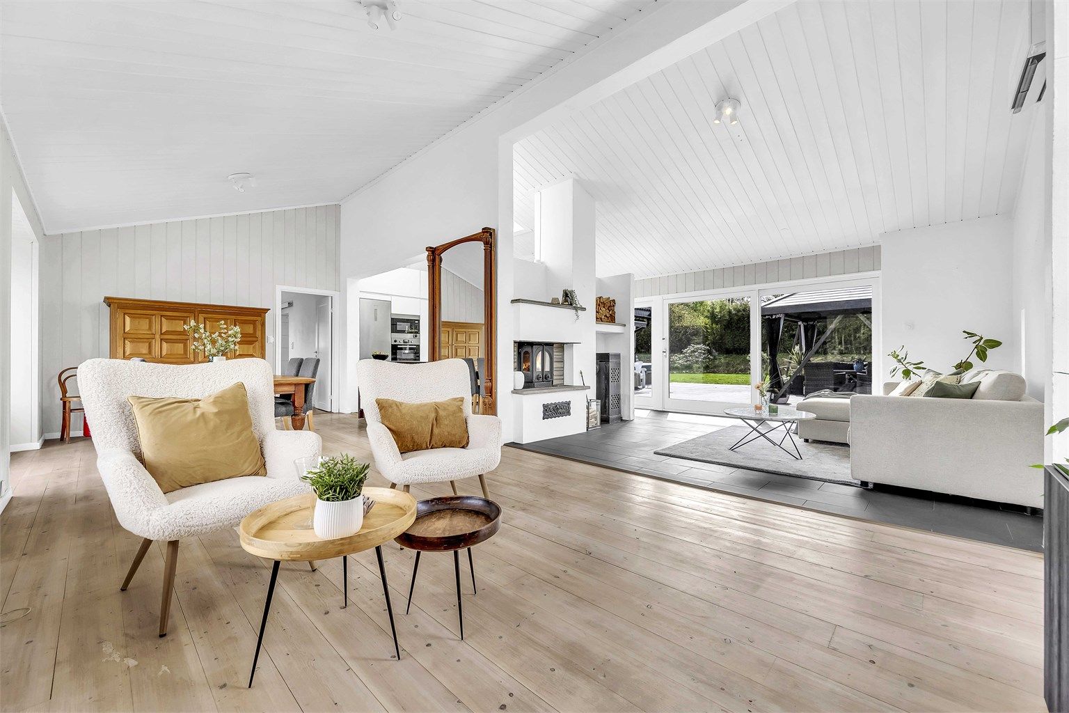 Lys og romslig stue med store vindusflater som gir rikelig med naturlig lys og en luftig atmosfære.