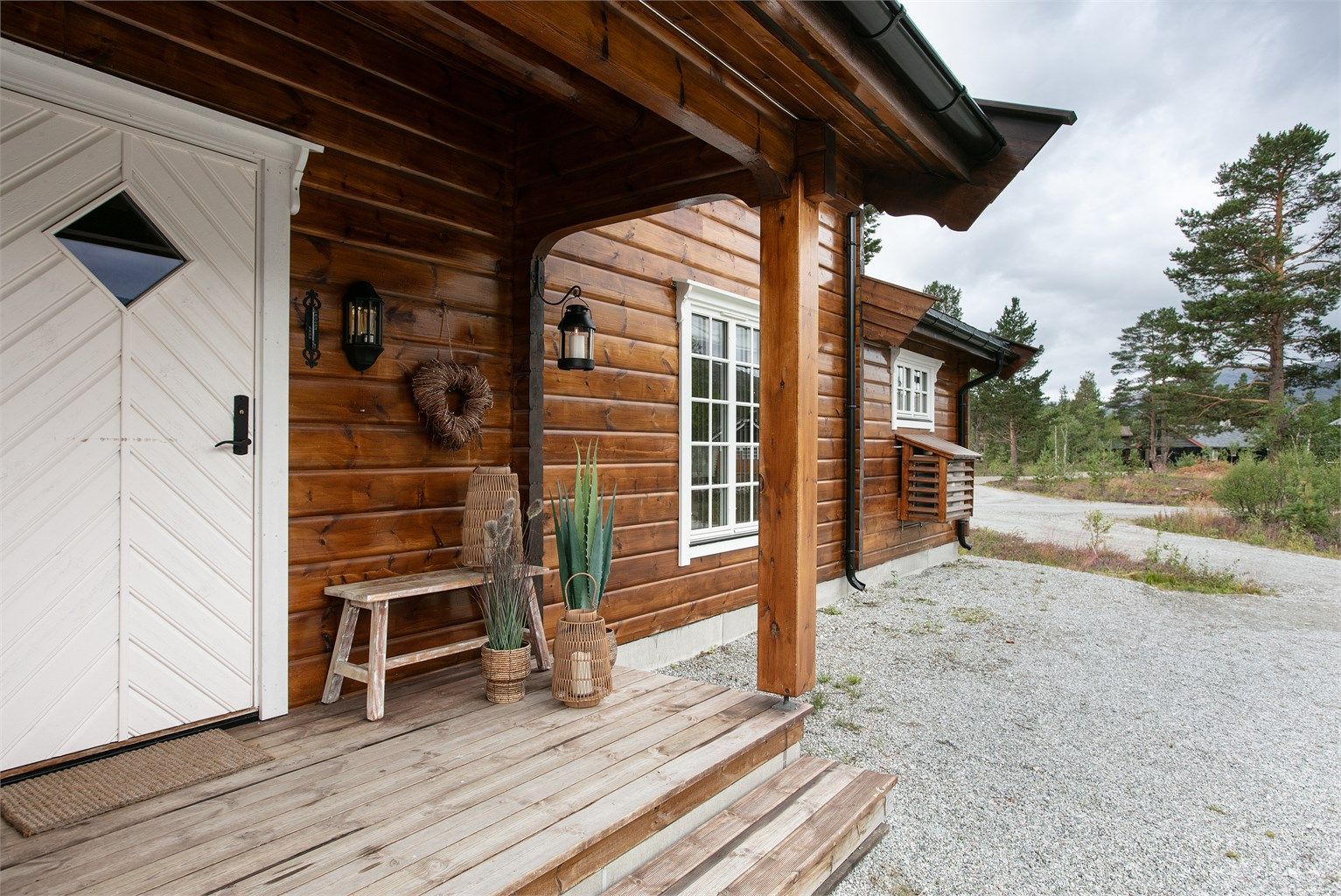 Overbygd inngangsparti og fasade i tømmer.