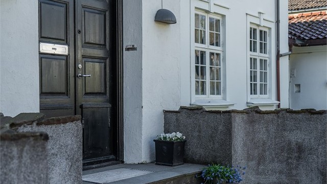 Inngangspartiet er fra gaten, her kommer man inn i entréen og videre inn i en lys hall med tilkomst til rommene i 1. etasje og trappeløp opp til 2. etasje og ned til kjelleretasjen.