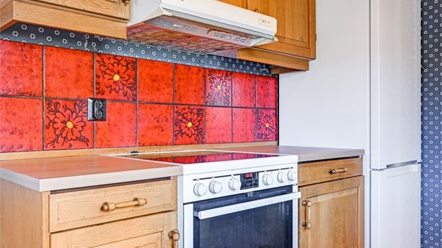 Kjøkkenet er utstyrt med komfyr, kjøleskap og kjøkkenventilator med avtrekk ut.