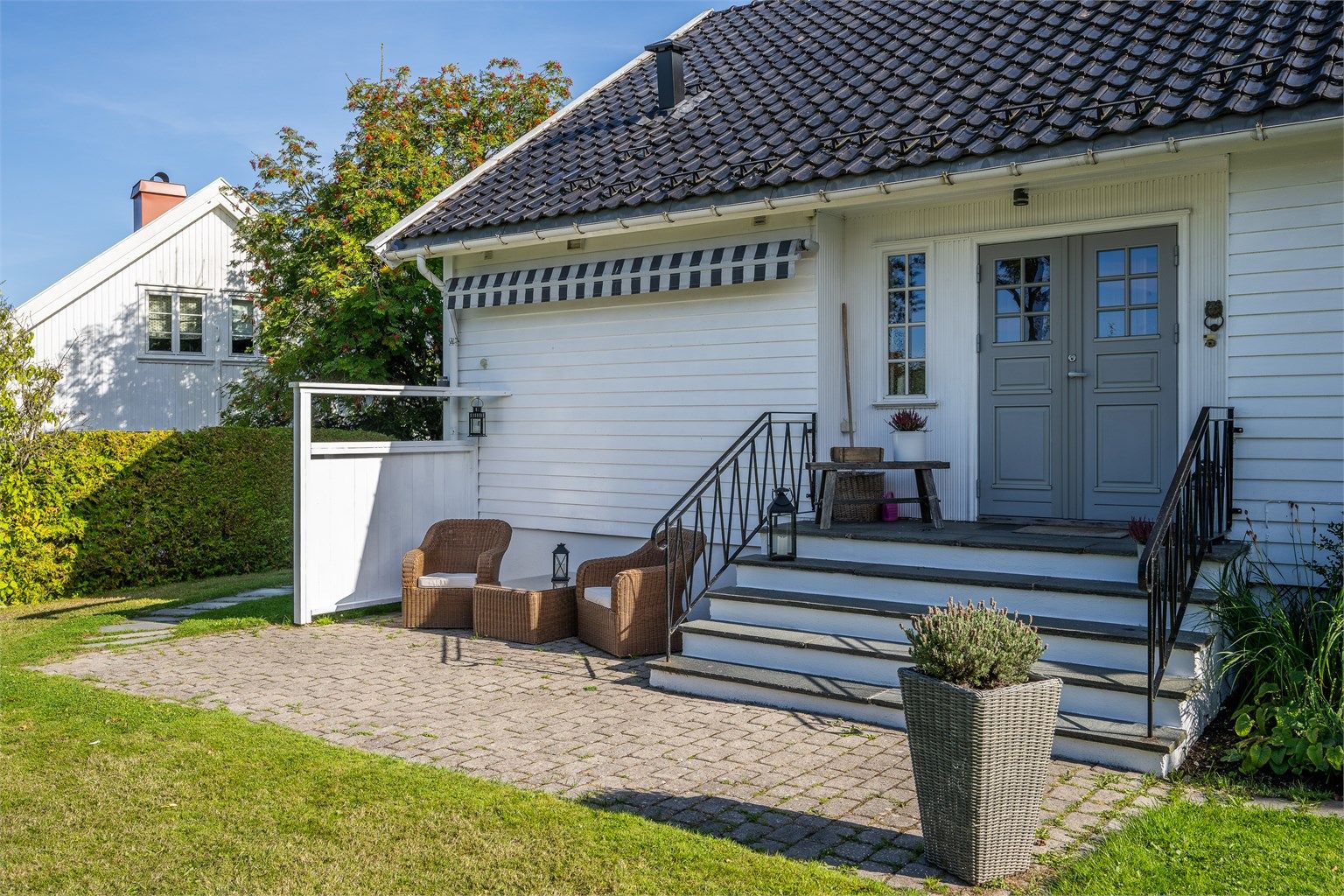 Markterrasse med belegningsstein foran hovedinngangen med plass til en hyggelig sittegruppe.