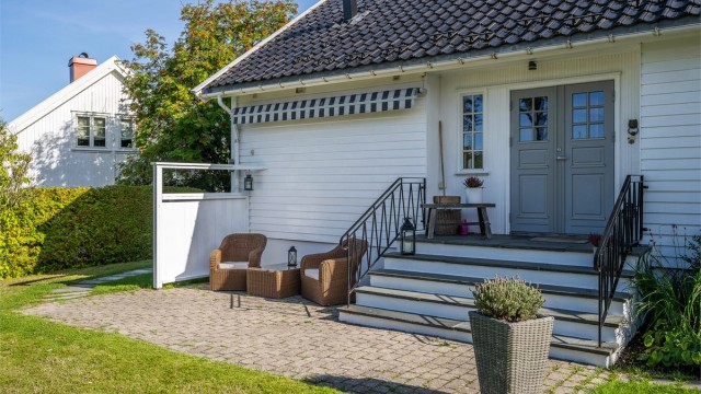 Markterrasse med belegningsstein foran hovedinngangen med plass til en hyggelig sittegruppe.