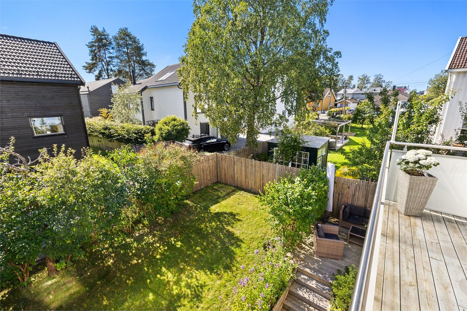 Fra balkongen er det utsikt over den frodige hagen og nærområdet.