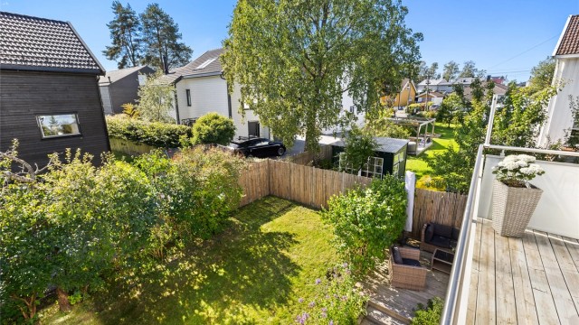 Fra balkongen er det utsikt over den frodige hagen og nærområdet.