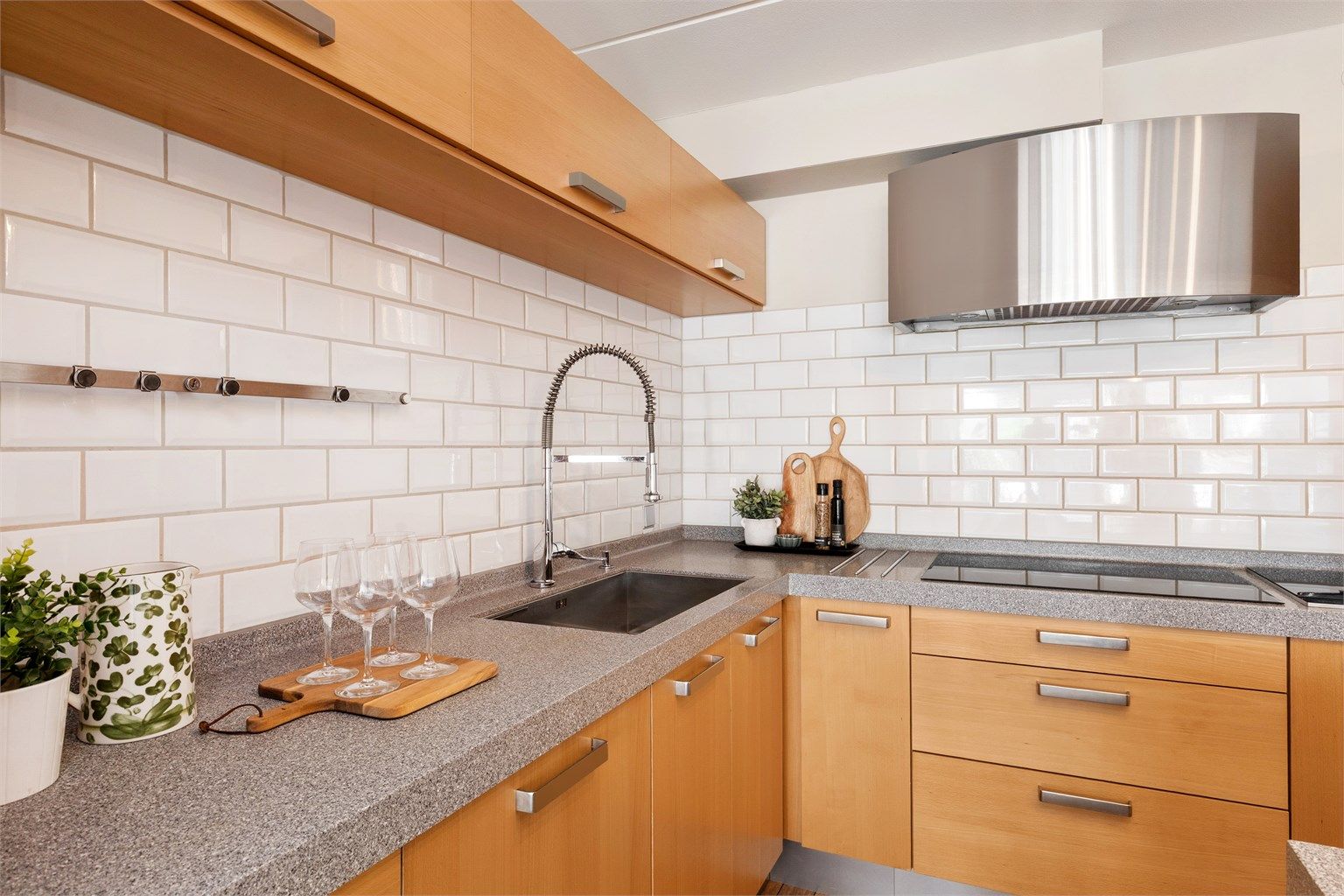 Benkeplaten er av Corian og er svært slitesterk, samtidig som den krever lite vedlikehold. Det er underlimt kum fra Blanco og armatur med spylefunksjon. Ventilatoren er fra den norske kvalitetsprodusenten RørosHetta.