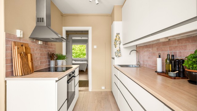 Pent Ikea-kjøkken med hvite, glatte fronter.