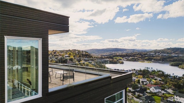 Glassrekkverket ivaretar den åpne utsikten, samtidig som det skjermer uteplassene mot vær og vind.