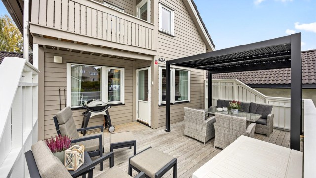 Uteområdet foran boligen med pergola og direkte adkomst fra inngangspartiet.