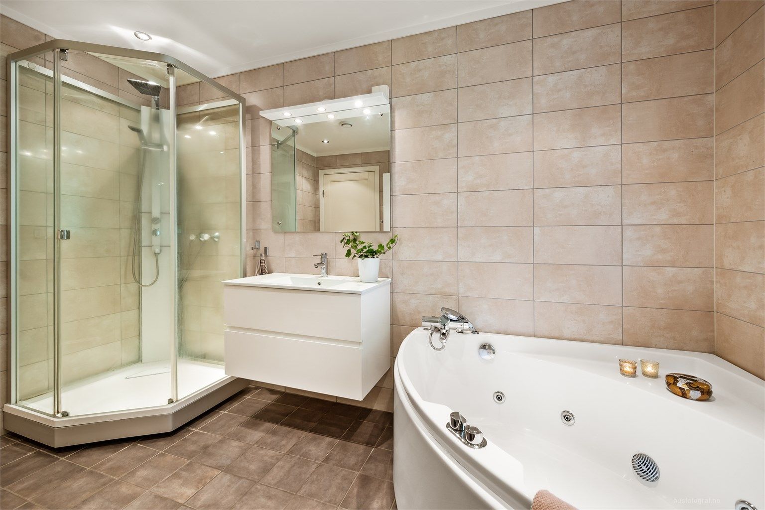 Badet har flislagt gulv med gulvvarme og downlights i tak.