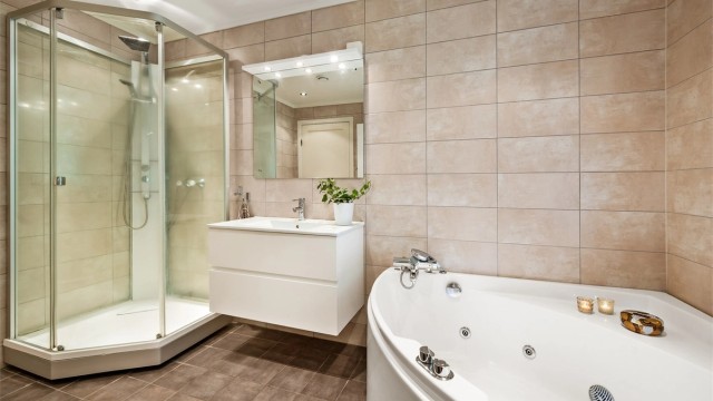 Badet har flislagt gulv med gulvvarme og downlights i tak.