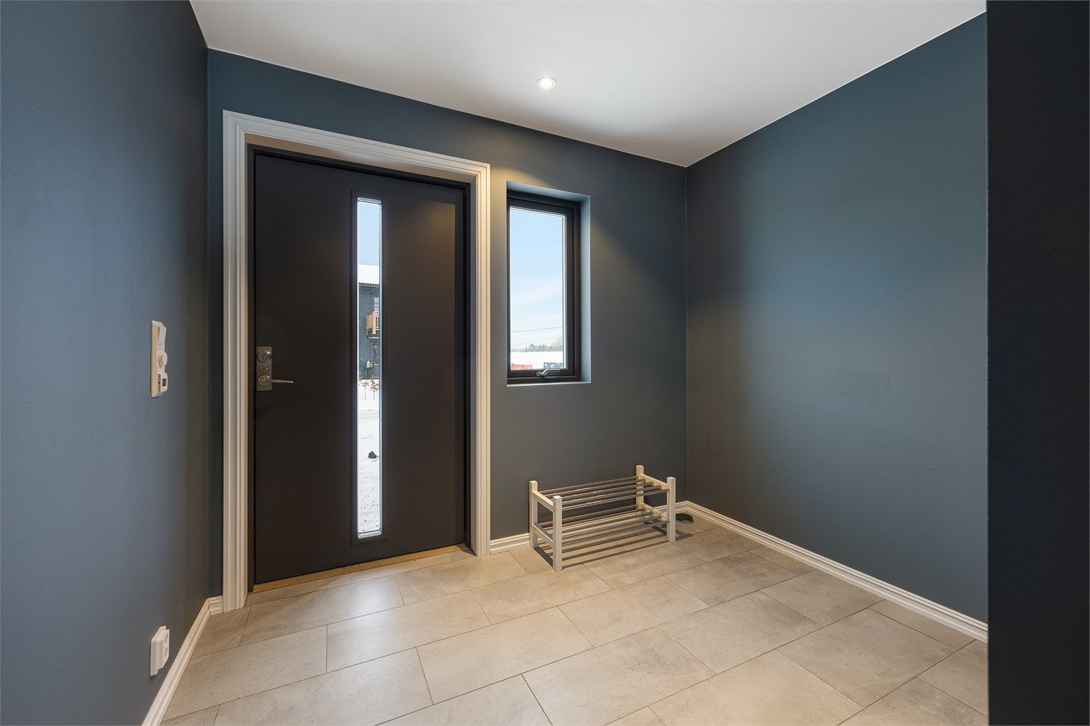 Entréen har store, lysegrå gulvfliser og behagelig gulvvarme.