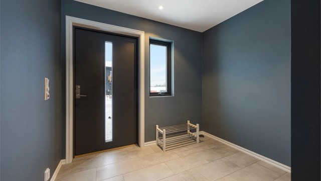 Entréen har store, lysegrå gulvfliser og behagelig gulvvarme.