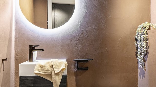 Leiligheten har et separat toalettrom, også fornyet i 2023 med mikrosement, og består av servant, speil og vegghengt toalett.