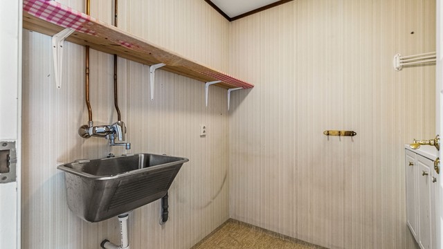 Vaskerom med utslagsvask, opplegg for vaskemaskin og varmtvannstank på ca. 200 liter.