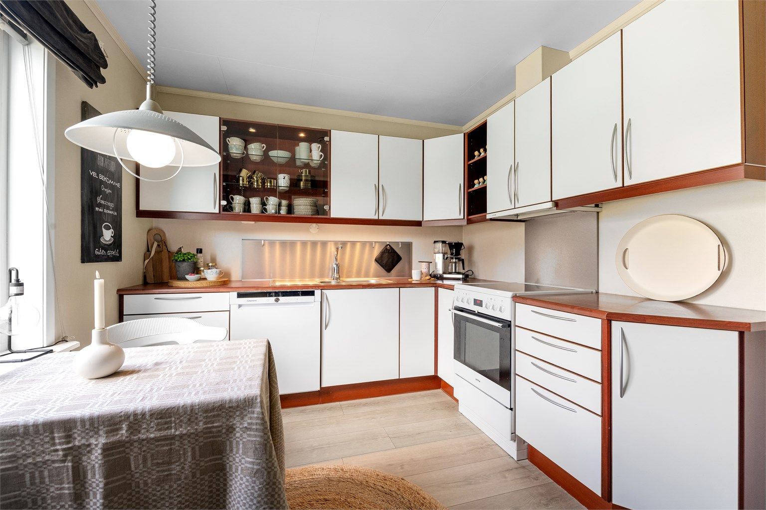 Kjøkkenet har en HTH-innredning fra byggeåret med glatte fronter og benkeplate med laminert overflate.