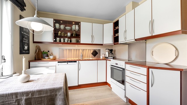 Kjøkkenet har en HTH-innredning fra byggeåret med glatte fronter og benkeplate med laminert overflate.