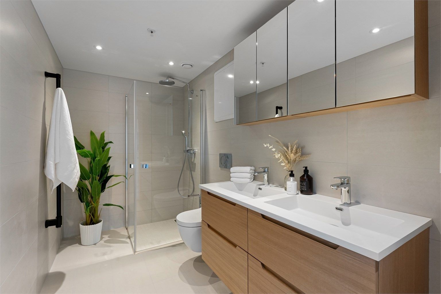 Lekkert og flislagt baderom med gulvvarme og downlights. Regnfallsdusj