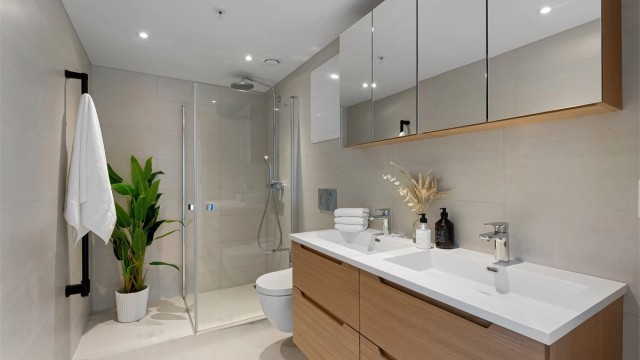 Lekkert og flislagt baderom med gulvvarme og downlights. Regnfallsdusj