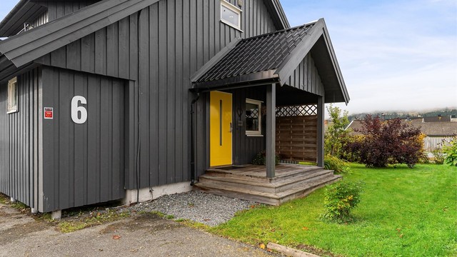 Overbygd inngangsparti med trapp i tre og ytterdør fra 2019.