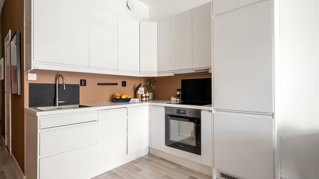 Kjøkkenet er utstyrt med glatte fronter, benkeplate av laminat, nedfelt oppvaskkum i tillegg til kjøleskap med fryser og integrert oppvaskmaskin, stekeovn og induksjonstopp.