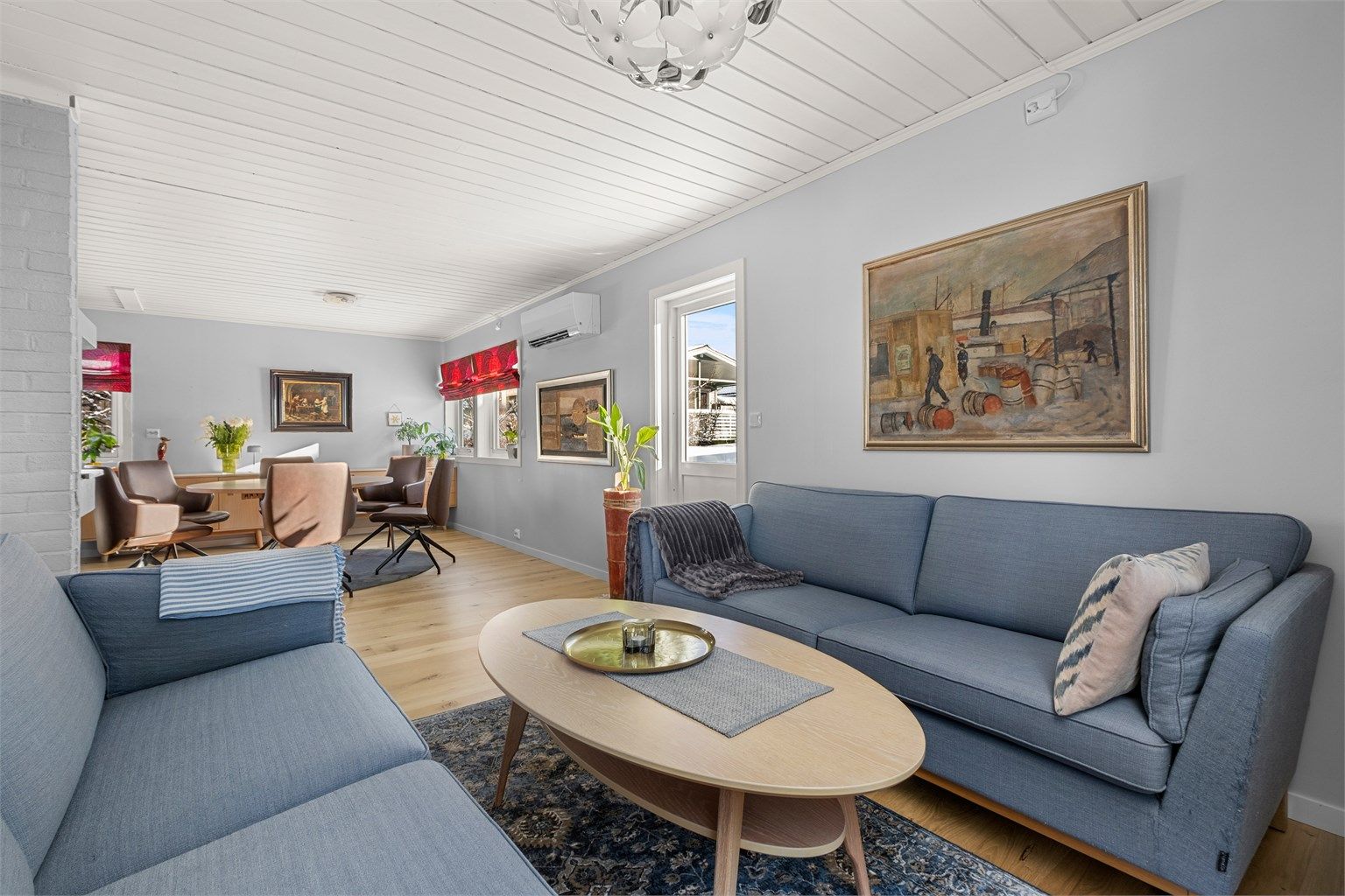 Stuen har en naturlig soneinndeling og god plass til både sofagruppe og TV-løsning. Vedovn bidrar til lun og hyggelig atmosfære.