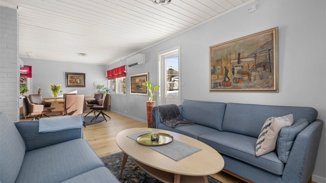 Stuen har en naturlig soneinndeling og god plass til både sofagruppe og TV-løsning. Vedovn bidrar til lun og hyggelig atmosfære.