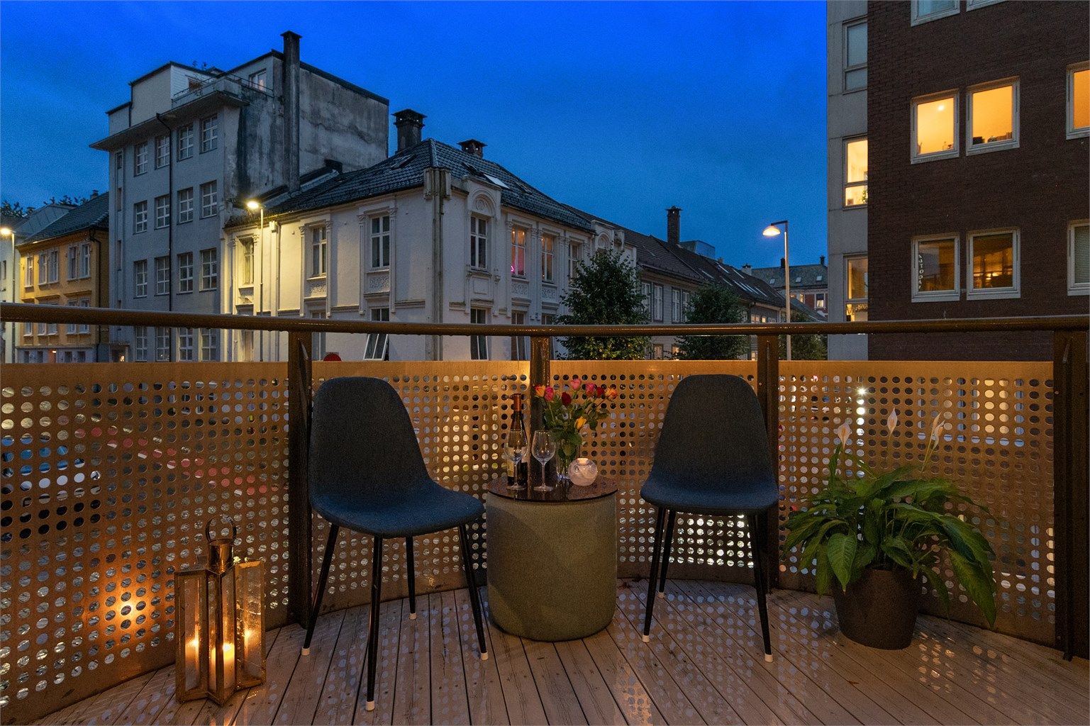 - Balkongen har gulvoverflater belagt med terrassebord og rekkverk i metall -