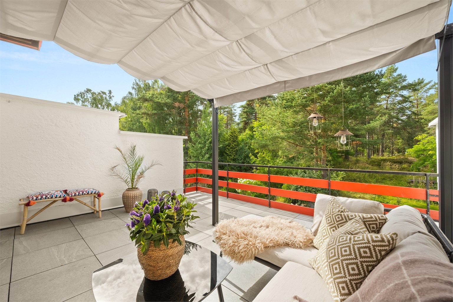 Altanen er belagt med store heller, og en frittstående pergola med uttrekkbar duk gir mulighet for skjerming over deler av sitteplassen.