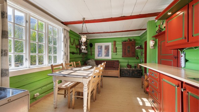 Kjøkkenet i hovedhuset har en romslig spiseplass og innredning med profilerte fronter.